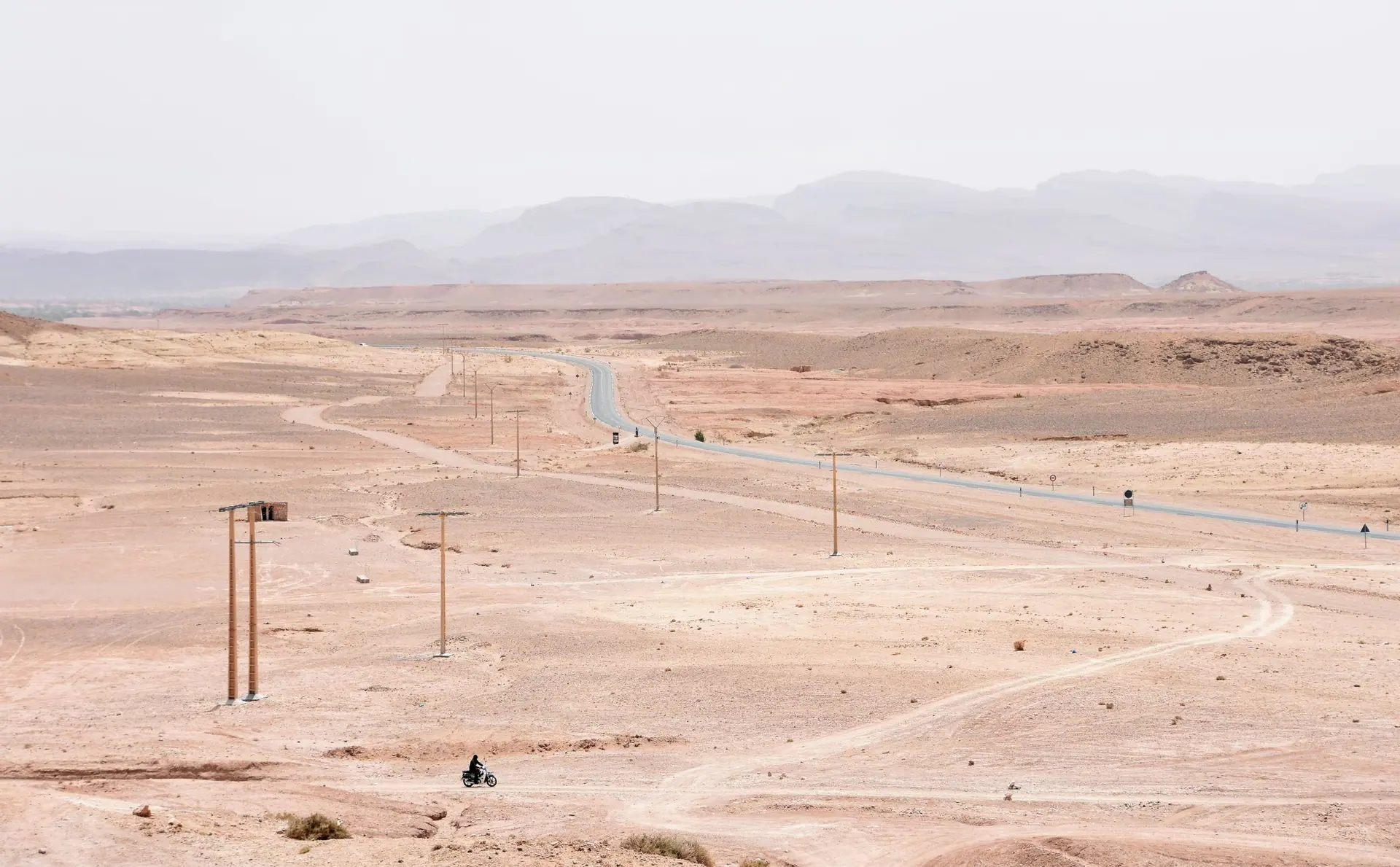 Expansive view of a desert road in Aït Benhaddou, Morocco, showcasing arid landscape.